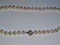 A pearl necklace with a diamond clasp. Learn how to tell if pearls are real by examining their luster and surface imperfections.