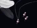 A delicate necklace and earrings featuring pink pearls, symbolizing love and purity. A white feather rests nearby, adding an ethereal touch.