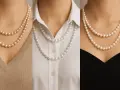 Three women showcase what is a pearl necklace: a classic double strand of pearls on a beige sweater, a single strand on a white blouse, and a double strand on a black dress.