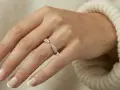 A hand with French manicured nails wears a sparkling rose gold ring. Rose gold is far from out of style!