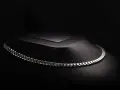 A sleek man platinum necklace rests on a dark, textured display.