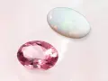 Two oval gemstones, a pink tourmaline and a white opal, are displayed. The opal's play-of-color makes it a perfect october 27 birthstone.