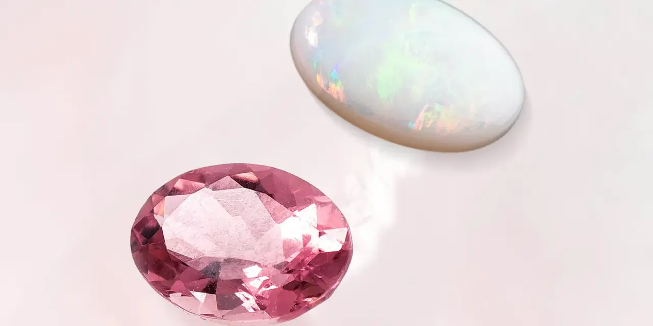 Pink tourmaline and opal, the two birthstones for October, shimmer on a pale background.