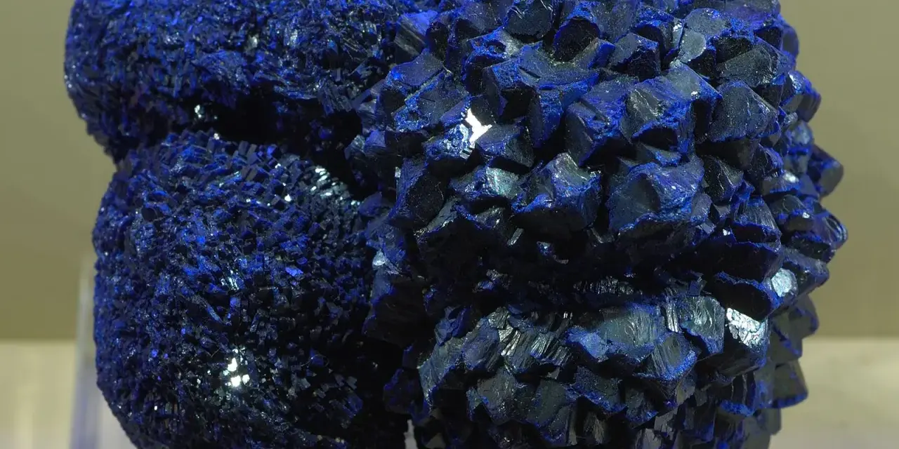 Clusters of vibrant blue azurite crystals, resembling a celestial formation, gleam under the light.