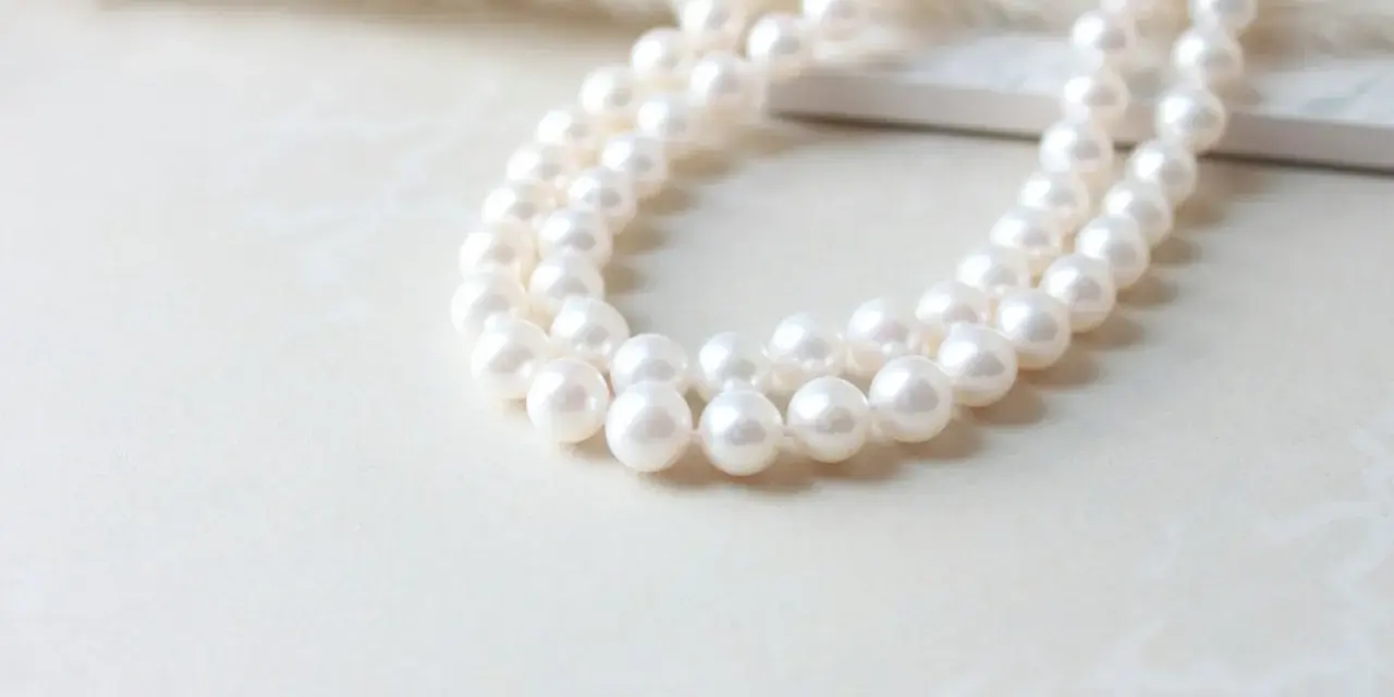 A double strand of luminous white pearls, symbolizing purity and elegance. The silver pearl meaning is often associated with wisdom and serenity.