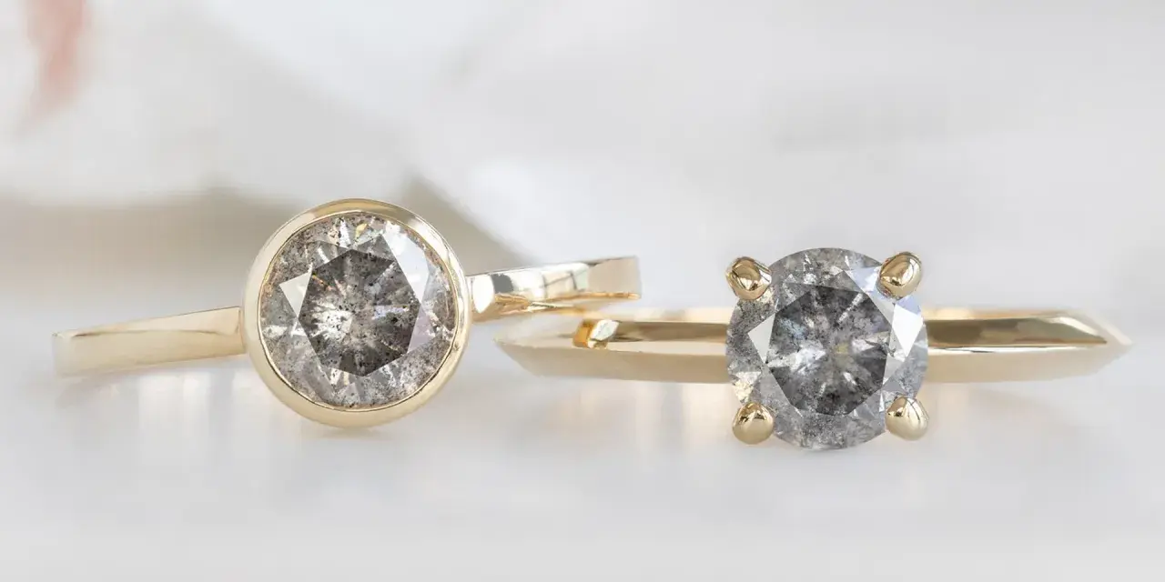 Two gold rings, one with a bezel setting and the other with a prong setting, showcase their unique diamond styles.