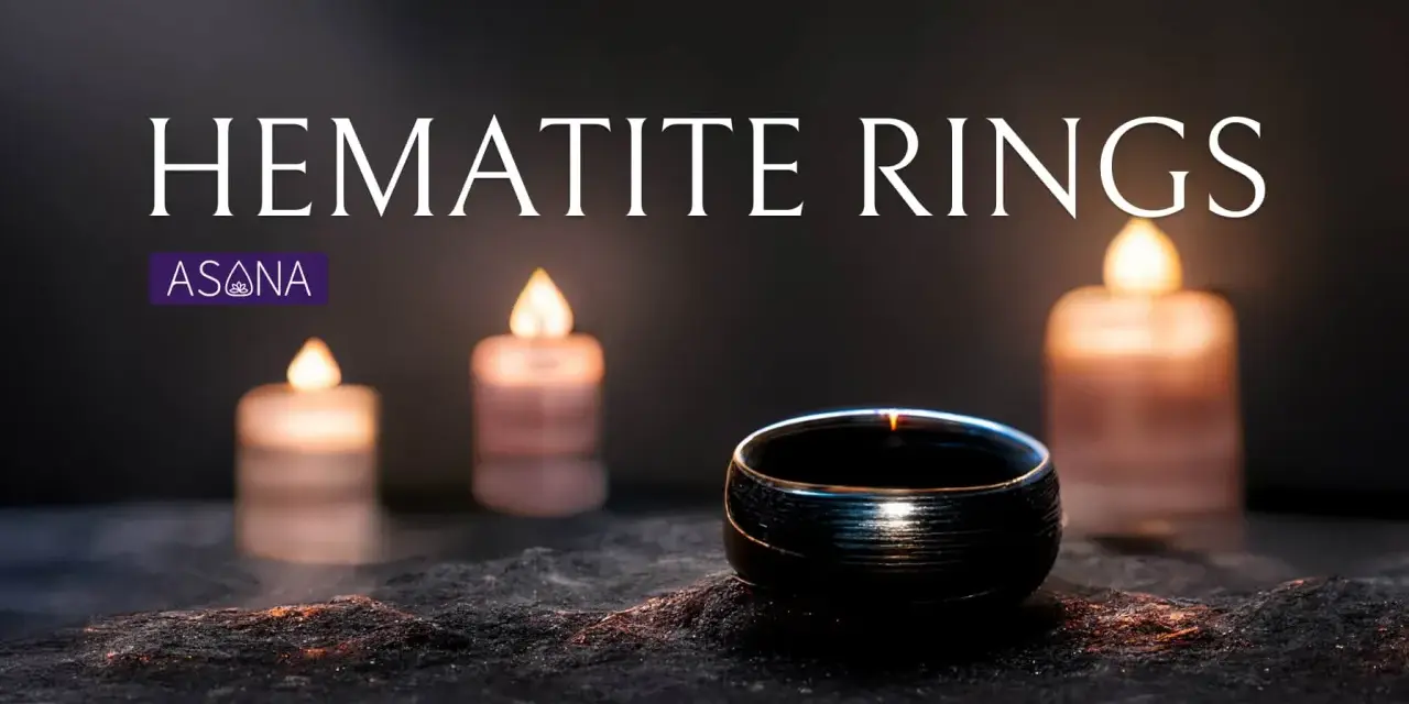 A dark hematite ring sits on a textured surface, illuminated by soft candlelight. Discover the hematite ring meaning.