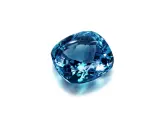 A cushion-cut blue gemstone, likely sapphire, what is September's birthstone, sparkles against a white background.