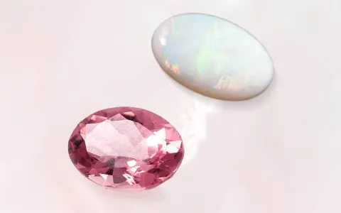 Pink tourmaline and opal, the two birthstones for October, shimmer on a pale background.