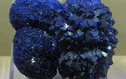 Clusters of vibrant blue azurite crystals, resembling a celestial formation, gleam under the light.