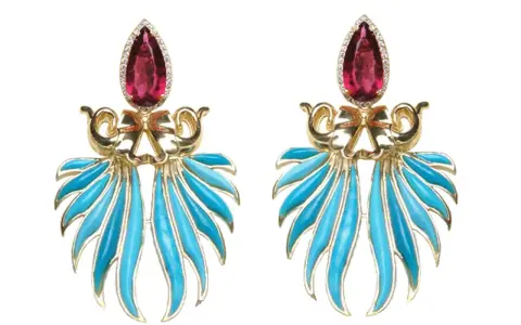 Exquisite gold earrings featuring a teardrop ruby and vibrant blue enamel, reminiscent of the rich colors found in brazilian stones.