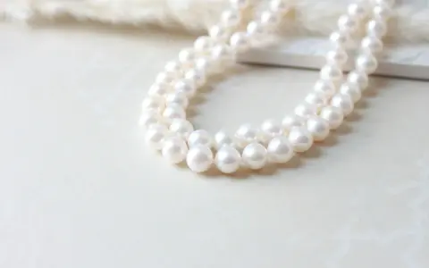 A double strand of luminous white pearls, symbolizing purity and elegance. The silver pearl meaning is often associated with wisdom and serenity.