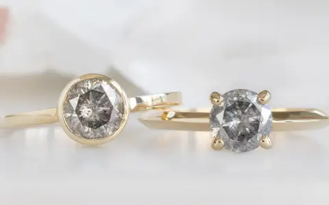 Two gold rings, one with a bezel setting and the other with a prong setting, showcase their unique diamond styles.