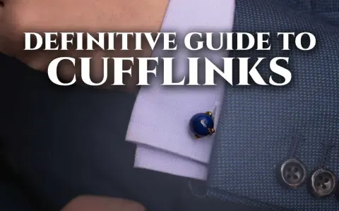 A close-up of a man's suit sleeve shows a blue lapis lazuli cufflink. This image is part of a definitive guide to cufflinks.