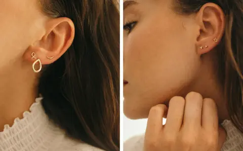 Chic ear stack ideas featuring delicate gold earrings: a teardrop charm, a curved bar, and tiny diamond studs.