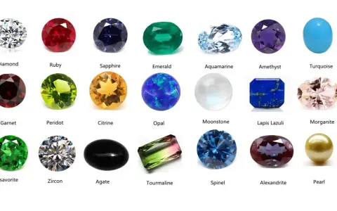 A collection of colorful gemstones, including a clear diamond, red ruby, blue sapphire, green emerald, and a pinkish morganite, a type of feldspar gemstone.