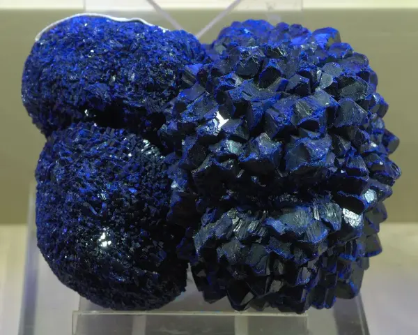 Clusters of vibrant blue azurite crystals, resembling a celestial formation, gleam under the light.