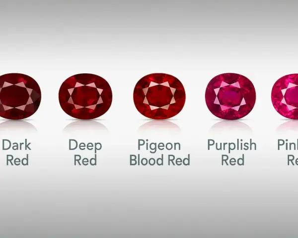 Five oval-cut rubies, showcasing a spectrum of red hues from dark to pinkish, represent the July birthstone.