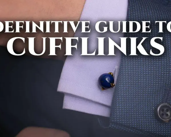 A close-up of a man's suit sleeve shows a blue lapis lazuli cufflink. This image is part of a definitive guide to cufflinks.