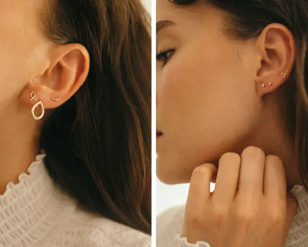 Chic ear stack ideas featuring delicate gold earrings: a teardrop charm, a curved bar, and tiny diamond studs.