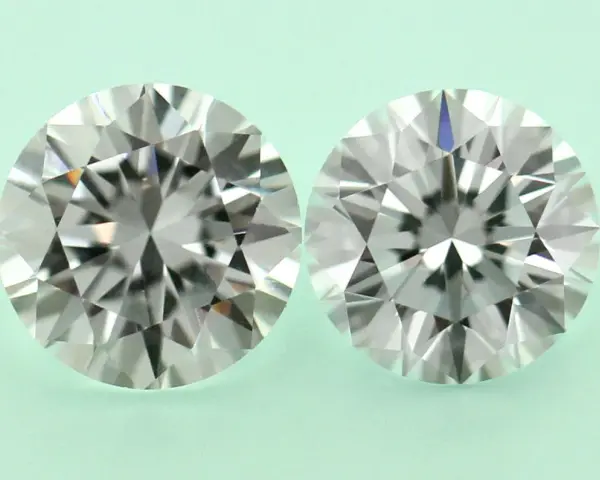 Two round brilliant cut diamonds, one a diamond simulant and the other lab grown, are shown side-by-side on a pale green background.