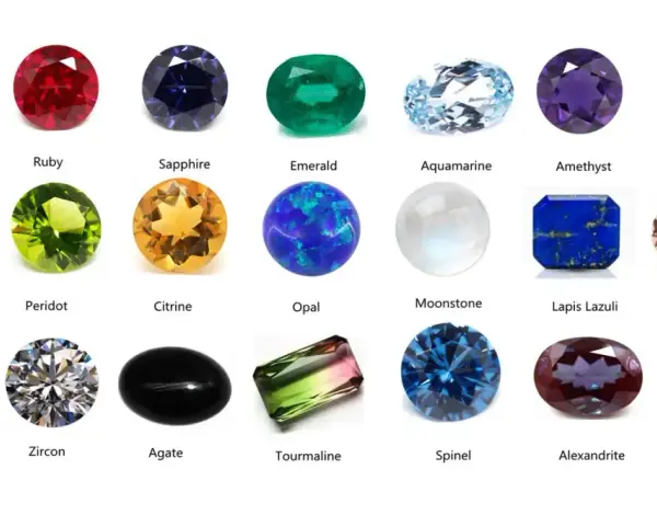 A collection of colorful gemstones, including a clear diamond, red ruby, blue sapphire, green emerald, and a pinkish morganite, a type of feldspar gemstone.