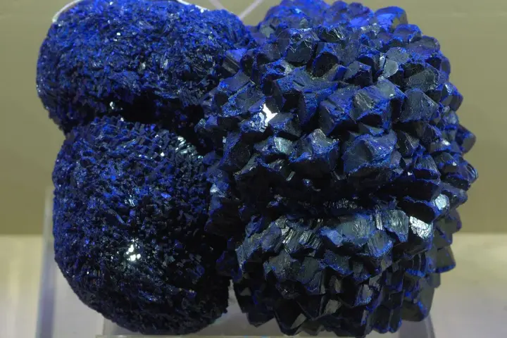 Clusters of vibrant blue azurite crystals, resembling a celestial formation, gleam under the light.