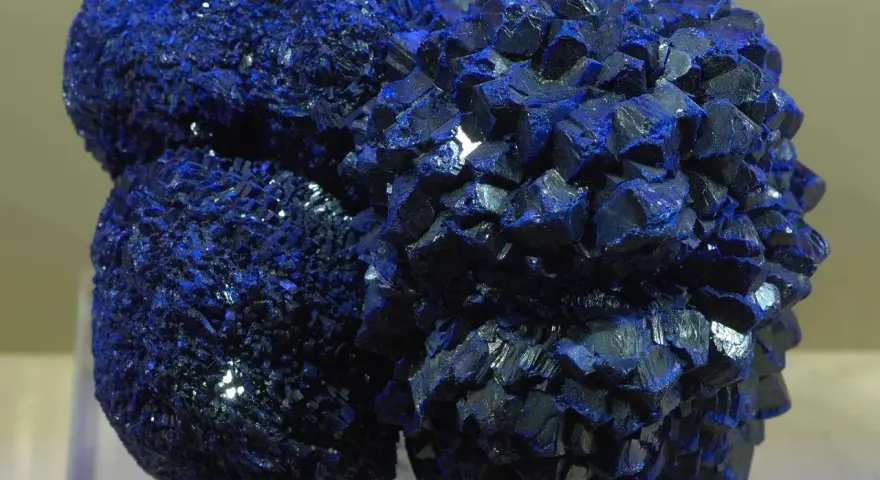 Clusters of vibrant blue azurite crystals, resembling a celestial formation, gleam under the light.