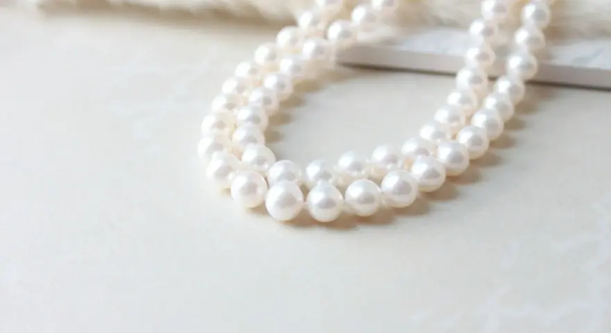 A double strand of luminous white pearls, symbolizing purity and elegance. The silver pearl meaning is often associated with wisdom and serenity.