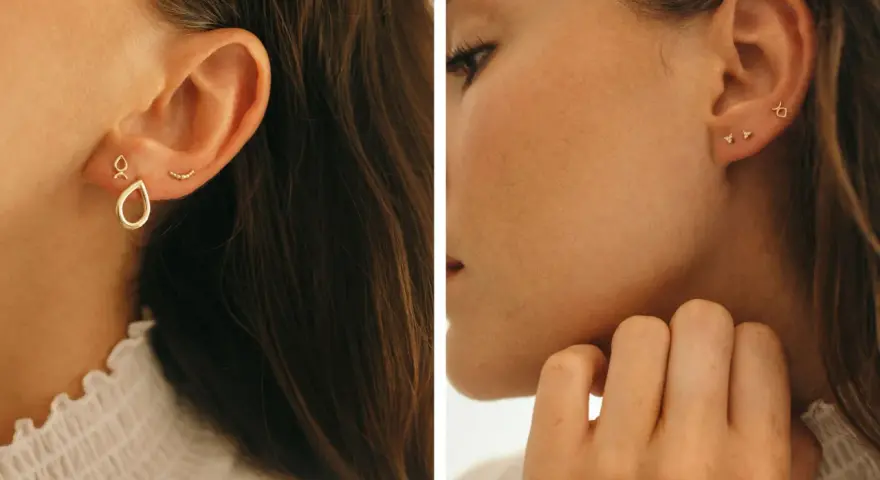 Chic ear stack ideas featuring delicate gold earrings: a teardrop charm, a curved bar, and tiny diamond studs.