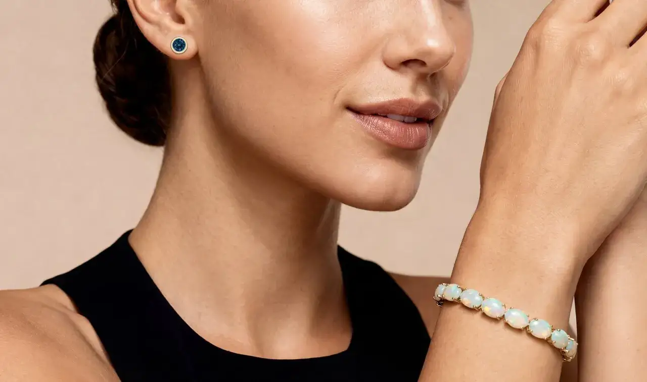 A woman wears a blue stud earring and a bracelet with opals, a beautiful scorpio birthstone.