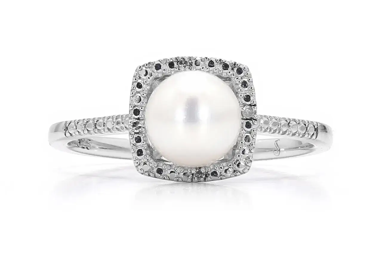 A silver ring with a central pearl, surrounded by small black stones. A perfect gift for a June birthday, as pearl is the birthstone month.