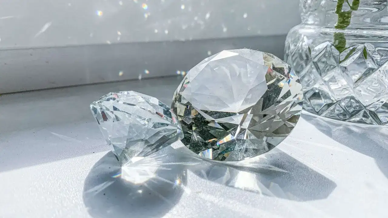 Two sparkling diamonds, one with a cushion cut and the other a radiant cut, catch the light.