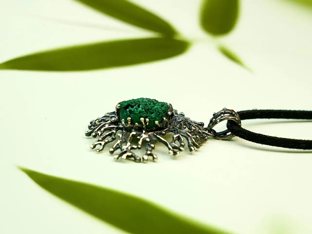 A unique silver pendant with a vibrant malachite stone, hinting at its protective malachite benefits.