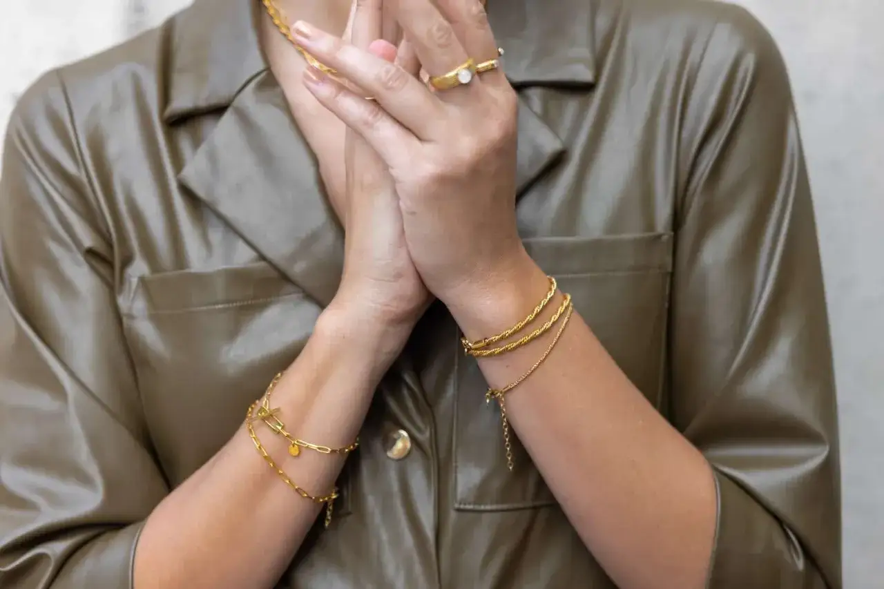 Gold bracelets stacked on a wrist, showcasing elegant tennis bracelet stack ideas.